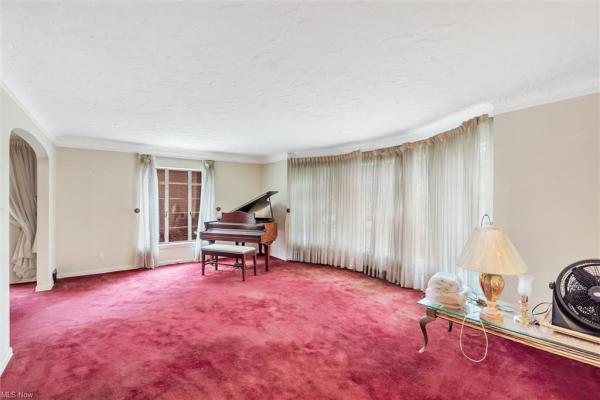 Living room with piano, wine-colored carpeting, and floor-length windows in Cleveland, Ohio house for sale, listed by Will Davis, Ohio probate specialist and realtor