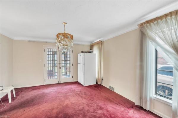 Dining room with refrigerator in corner, double doors leading outside, window with floor-length curtains in Cleveland, Ohio house for sale, listed by Will Davis, Ohio probate specialist and realtor