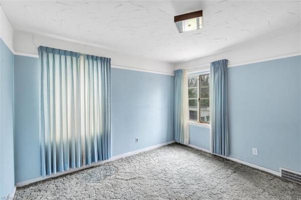 Bedroom with light blue walls, light blue curtains, gray blue carpet, and two windows in Cleveland, Ohio house for sale, listed by Will Davis, Ohio probate specialist and realtor