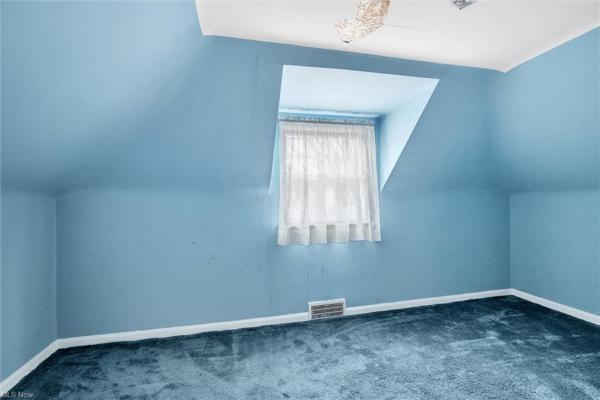 Bedroom with light blue carpeting, light blue walls, and window in Cleveland, Ohio house for sale, listed by Will Davis, Ohio probate specialist and realtor