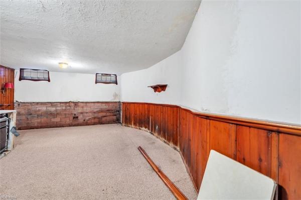 Rec room with wood and brick paneling halfway up walls, and beige carpeting in Cleveland, Ohio house for sale, listed by Will Davis, Ohio probate specialist and realtor